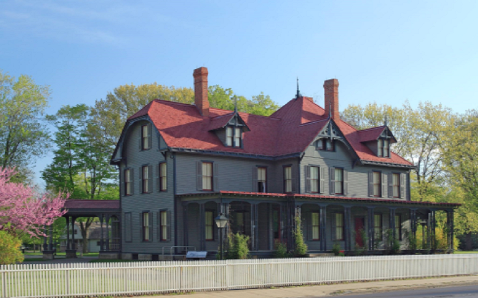 a house that is painted a orange color with bluish colored trim