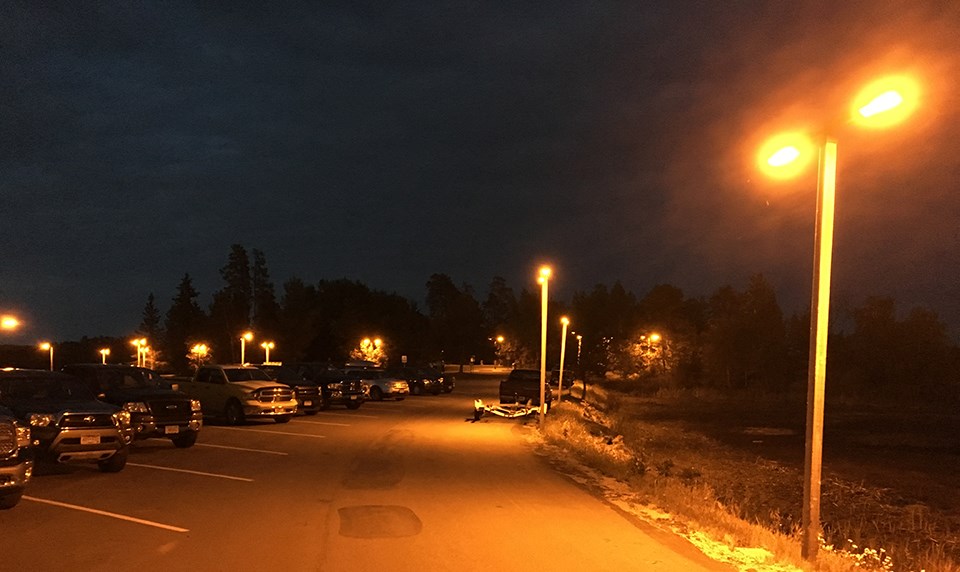 Tall lights at a parking lot  contribute to sky glow and spill light significantly into the wetlands beyond the parking area.