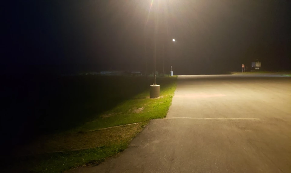 Tall lights at a parking lot  contribute to sky glow and spill light significantly into the wetlands beyond the parking area.