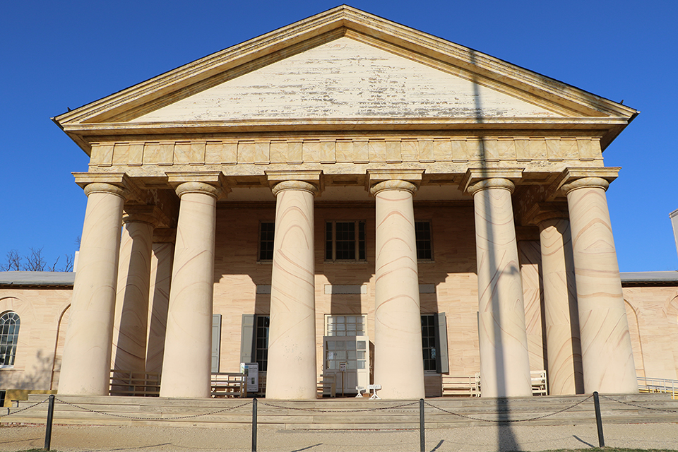 Front columns of Arlington with peeling paint.