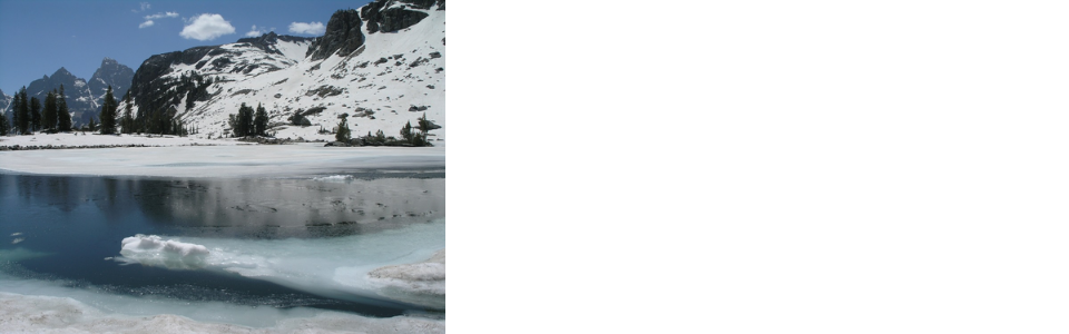 Snow melting on the surface of Lake Solitude with the Grand Teton and Mt. Owen in background.