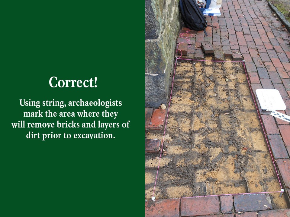 An archaeologist uses a book to match the dirt sample found where the artifact was located.