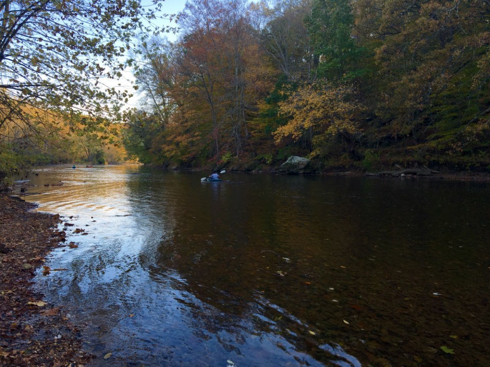 A person in a kayak travels down the Brandywine Creek on a mid fall day.