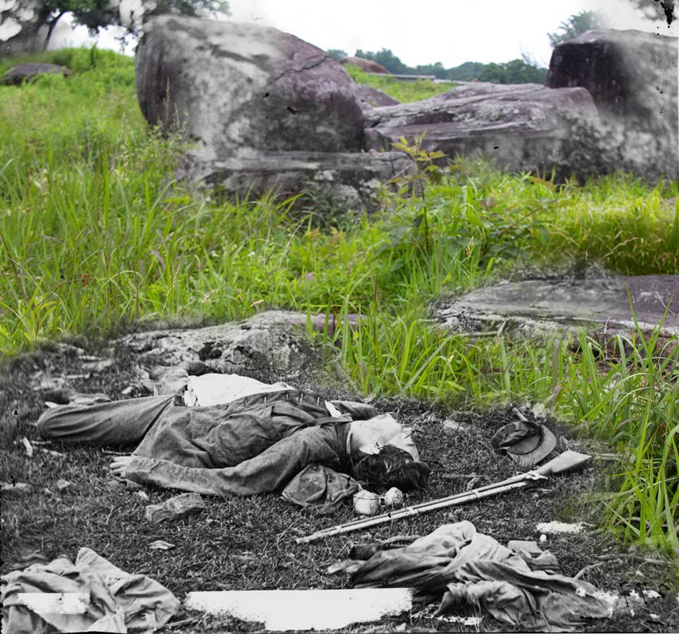A dead soldier lies in front of rocks near Devil’s Den.