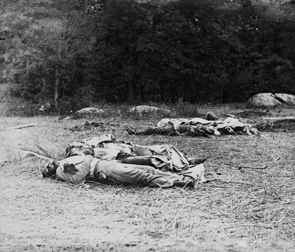 A group of Confederate dead lie near the edge of the Rose Woods.