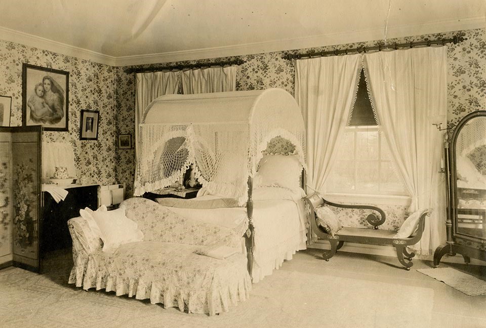 Interior of room with canopy bed and two chaise lounges