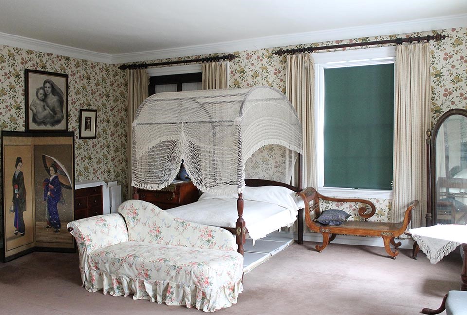 Interior of room with canopy bed and two chaise lounges