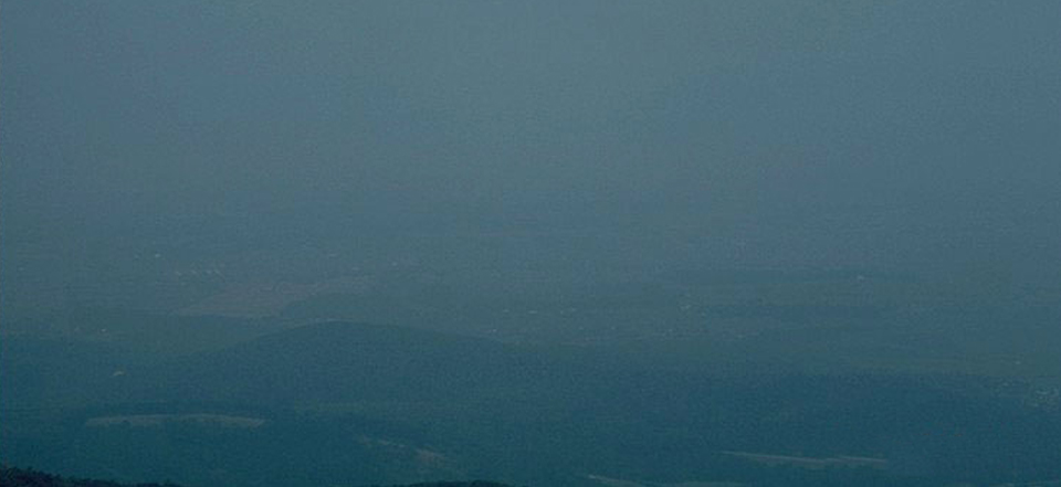 A photograph looking out towards New Market Gap from Skyland, blanketed in haze.