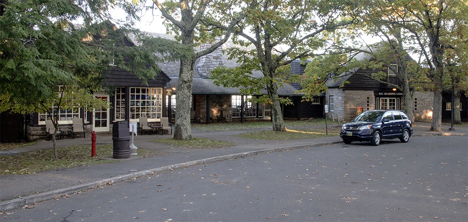 A black and white photograph of a lodge with a driveway.