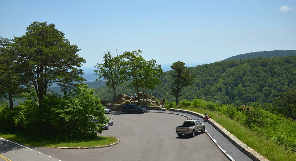 A black and white photograph of an overlook with mountain sin the distance.