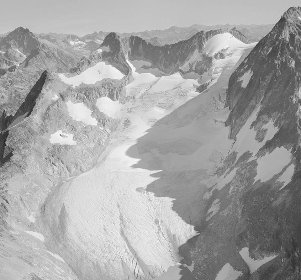 Black-and-white photo of a glacier extending to the bottom of the frame