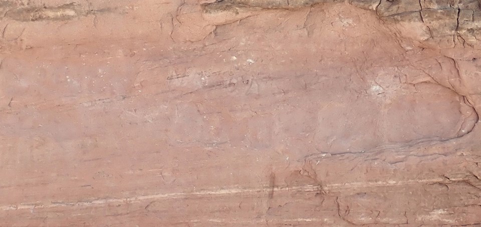 a rock wall with carved letters in it