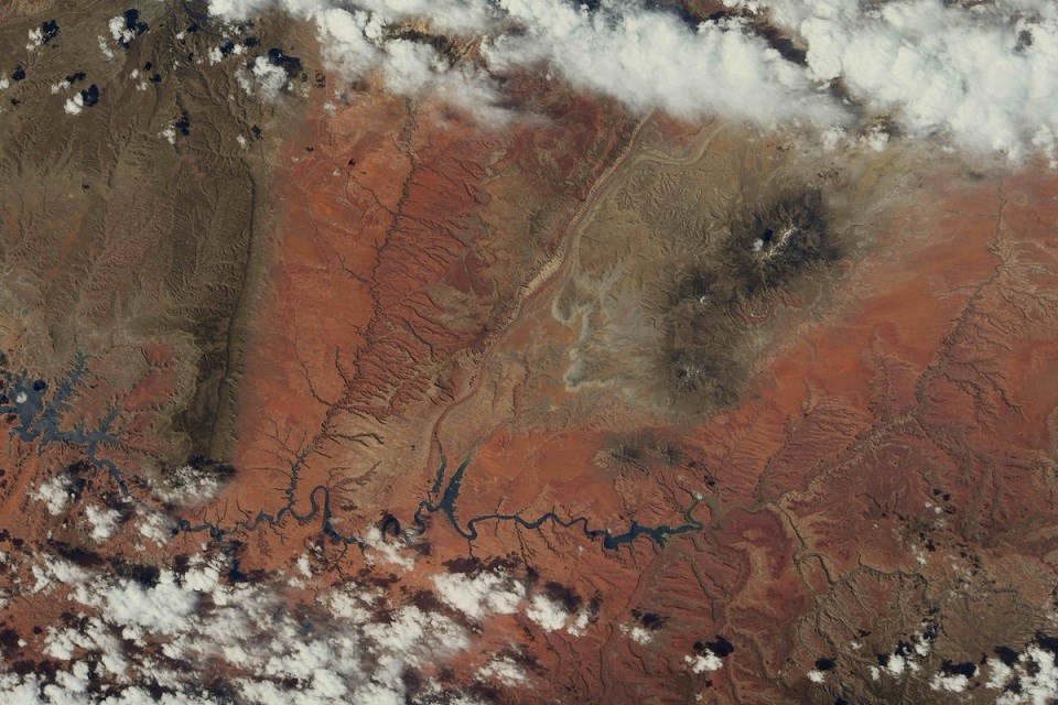 Aerial view of a large desert area with waterways and clouds