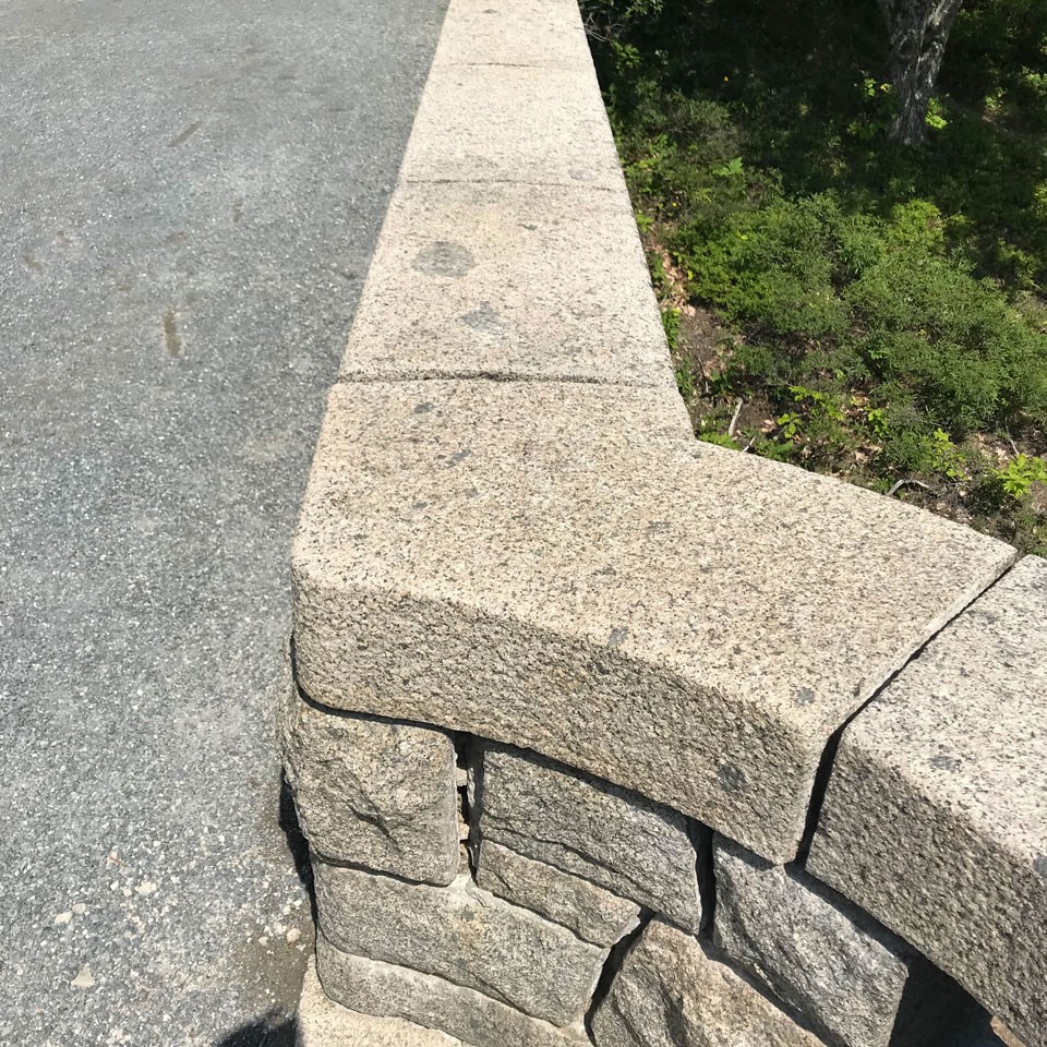 a gray stone bridge with dark spots on it