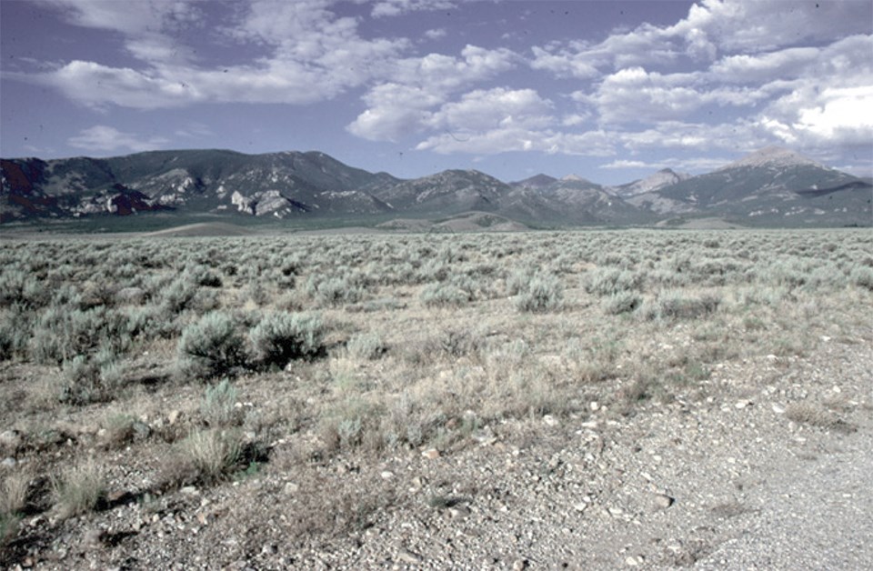 rocky basin with mountains in background