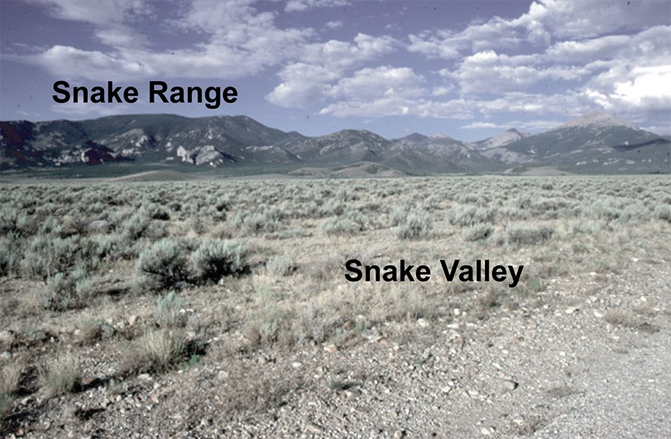 rocky basin with mountains in background