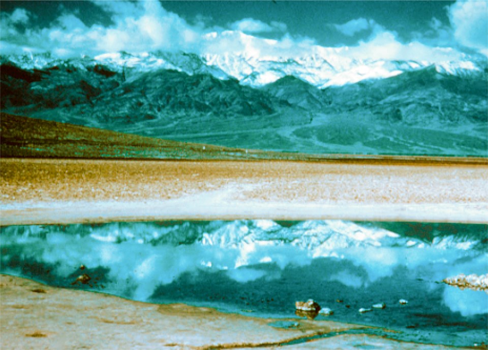water in desert basin with mountains in background