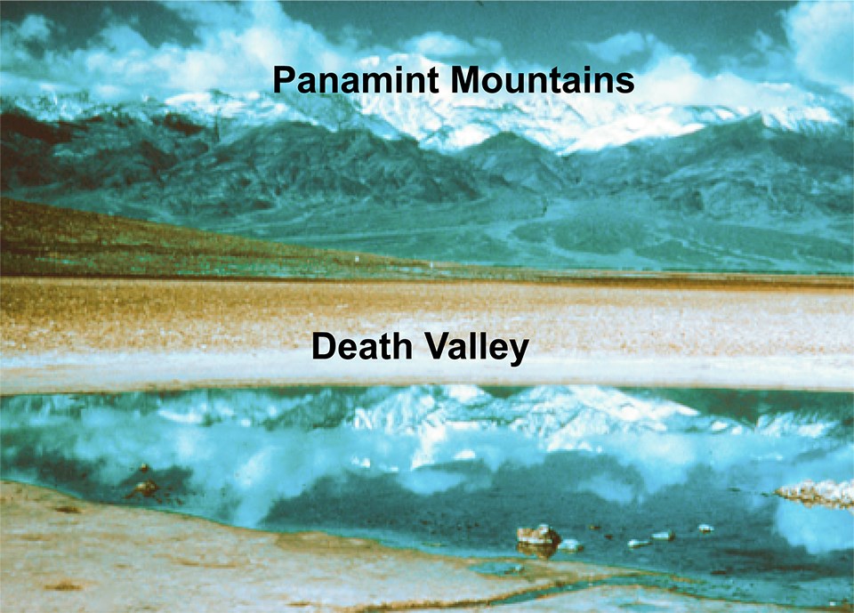 water in desert basin with mountains in background