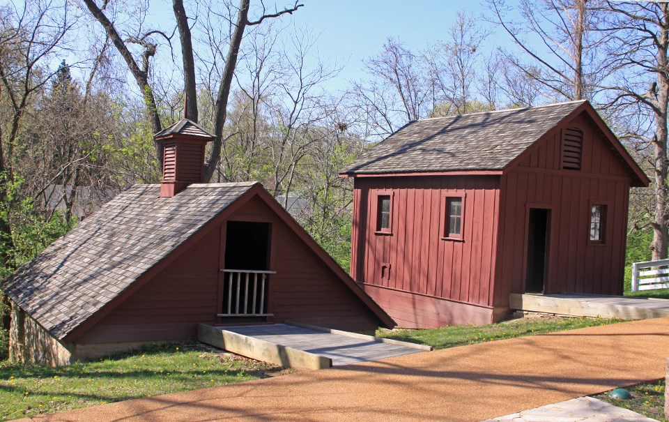 Historic black and white photo of a 19th century chicken house and ice house, side by side.