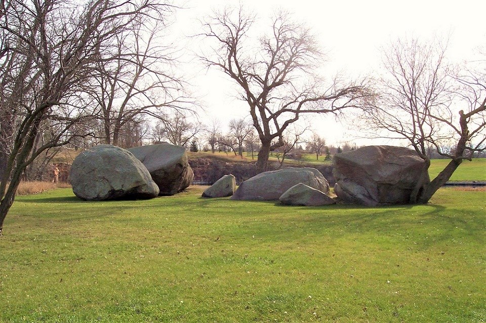 Old photo of man standing on boulders