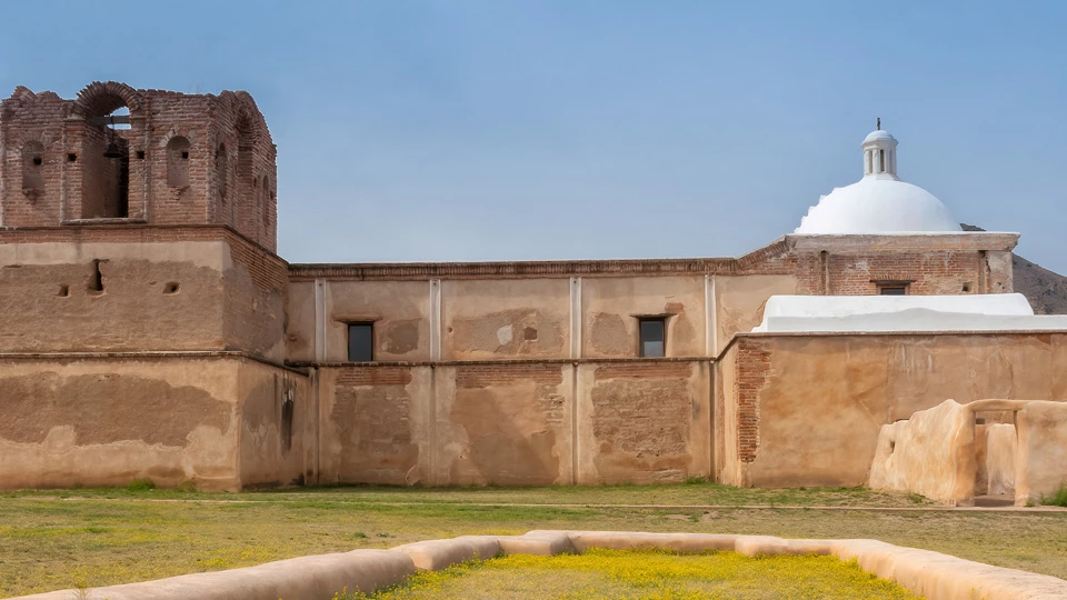 historic photo of east wall of church, with small nubs of pillars below