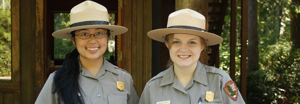 Two women rangers in front of a fee booth