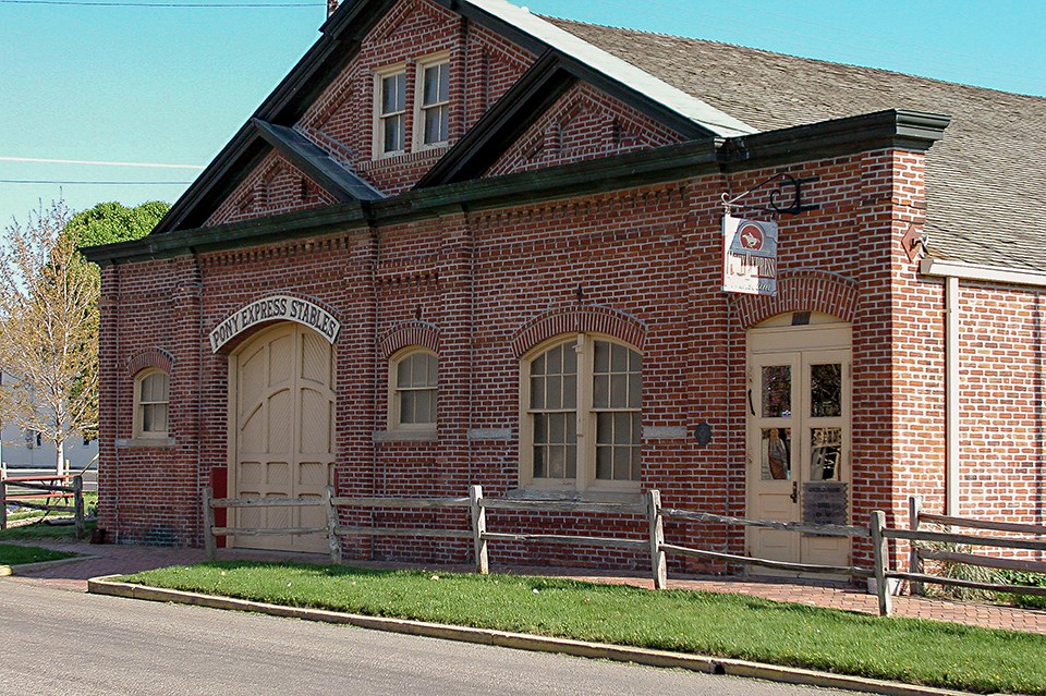 A large historic red brick stable building.