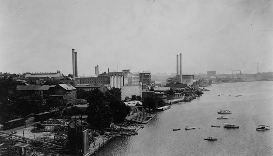 A black and white image showing buildings crowded around the waterfront