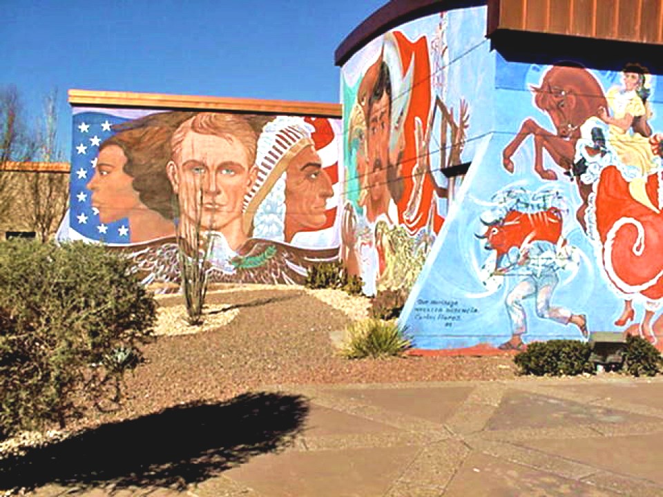 Mural panel showing faces from left to right of White astronaut, Barack Obama, and a Native American leader. An eagle with wings spread and arrows in one talon and olive branches in another below the three faces.