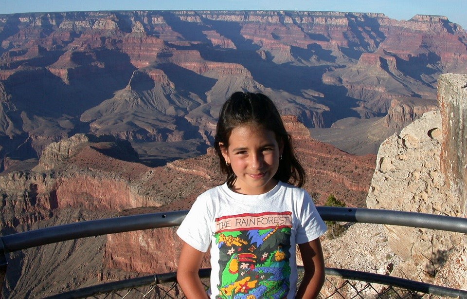 A young Nicole standing at an overlook of a very big canyon