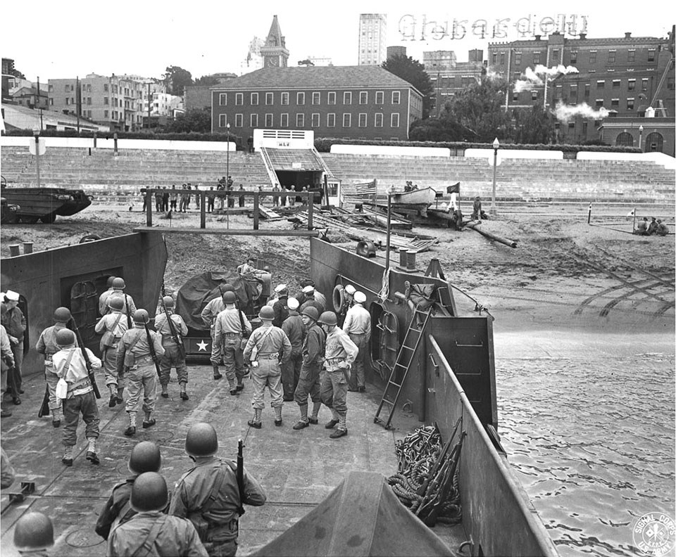Historic photo of soldiers in a boat with Ghirardelli in the background
