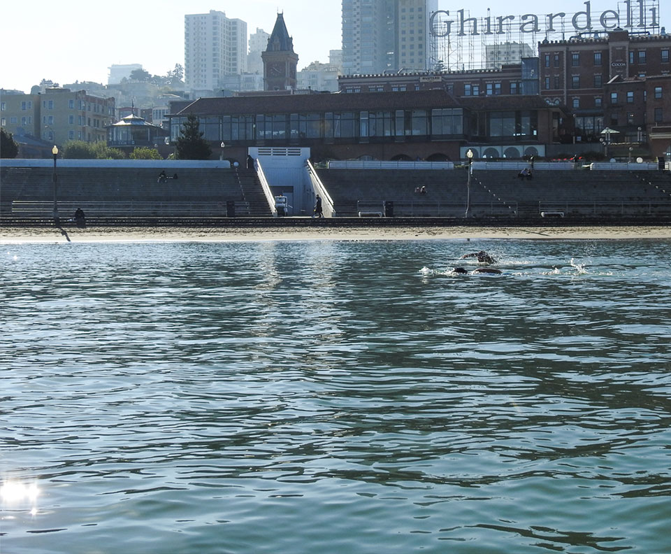Historic photo of soldiers in a boat with Ghirardelli in the background