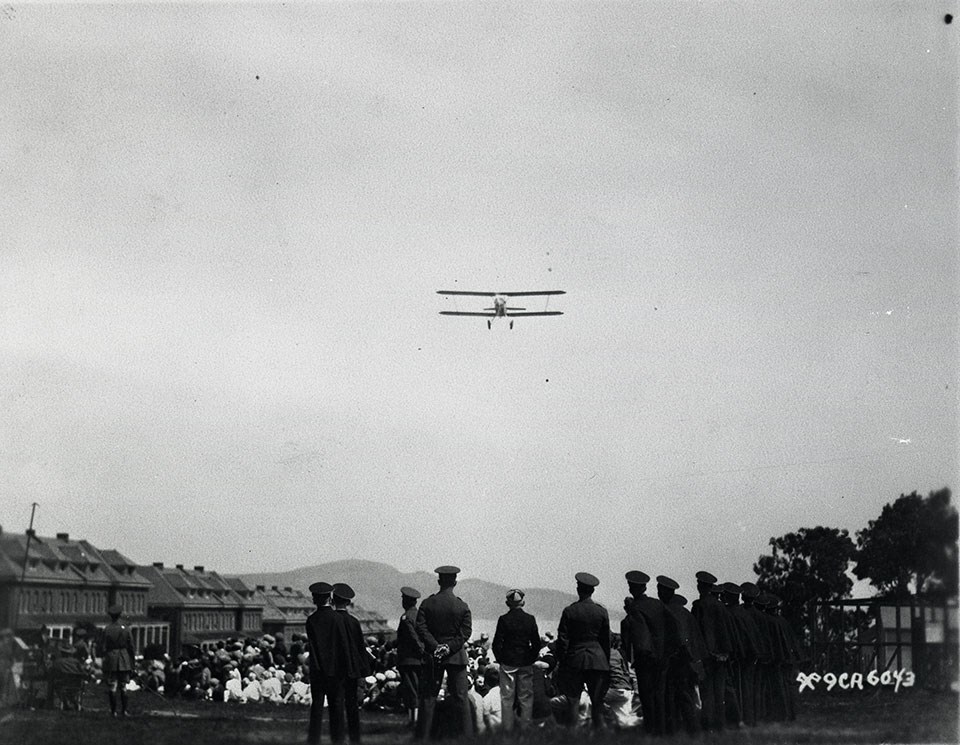 Photo of a biplane flying over the Presidio 1929
