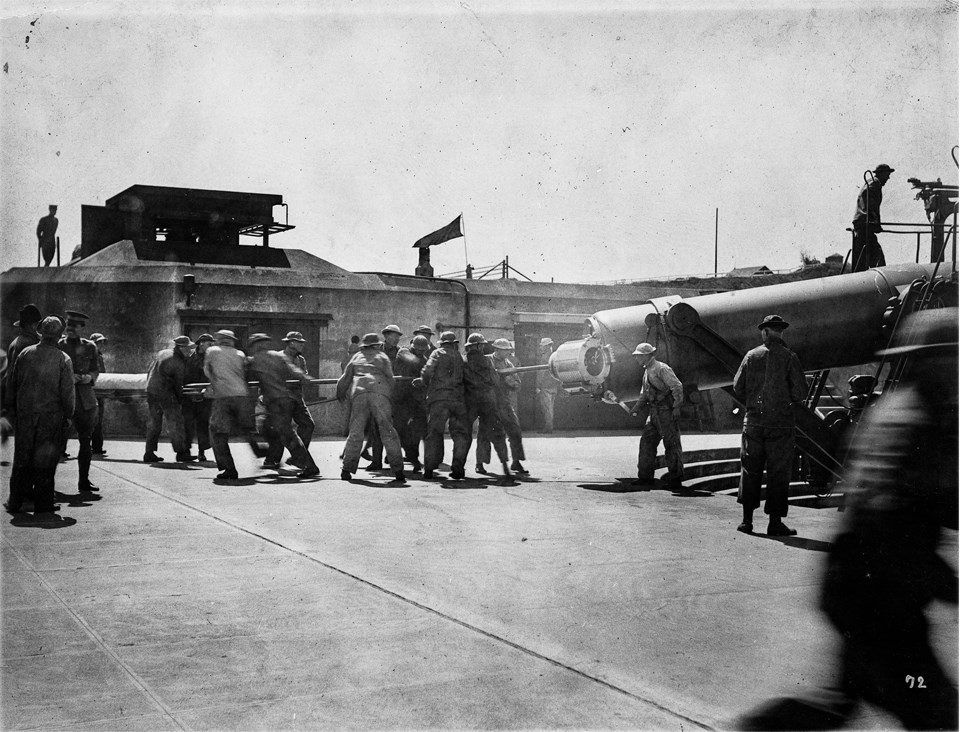 a group of soldiers loading projectiles into the disappearing gun