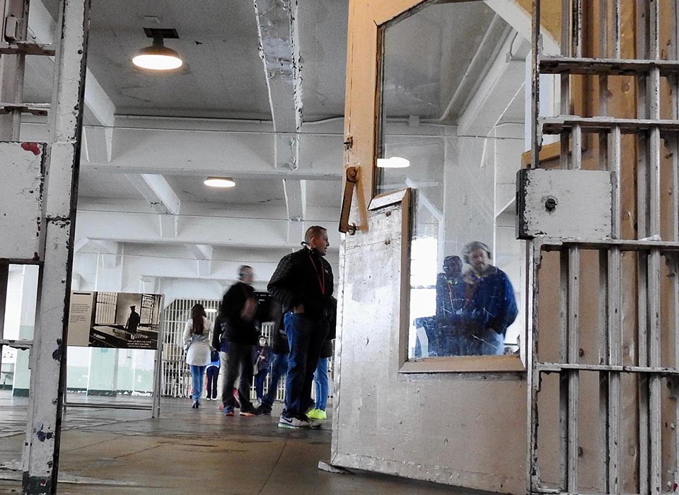 view of visitors in the Alcatraz dining hall from cell door