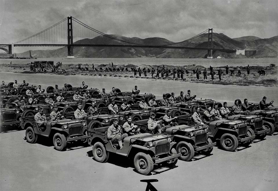 a grassy field with the golden gate bridge in the background