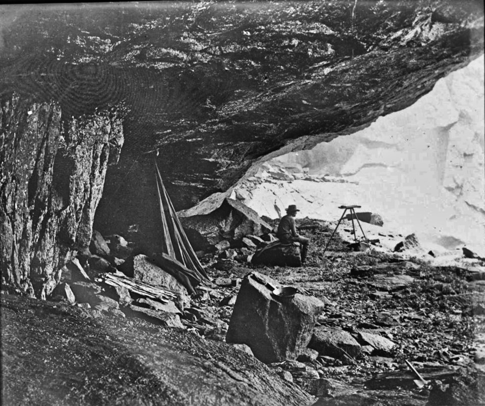 Man sits on a rock inside a cave