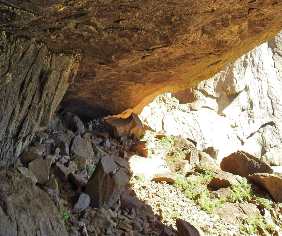 Man sits on a rock inside a cave