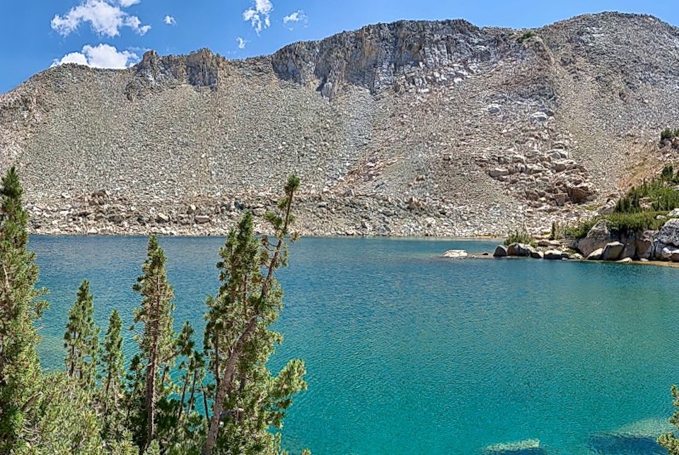 Color painting of lake with mountain ridge behind.