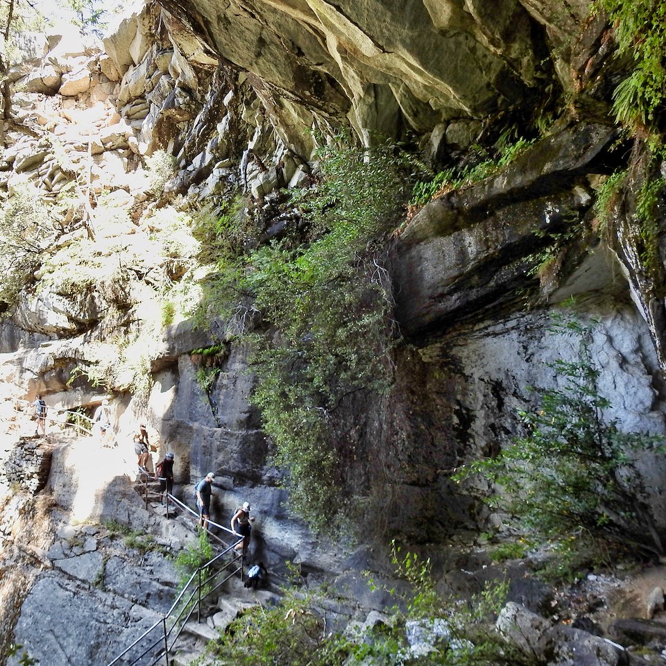 Wooden ladders and walkways climbing up a cliff.