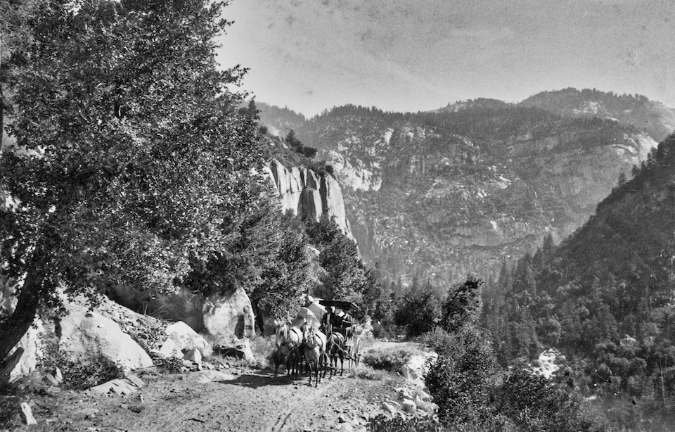 Stagecoach on a road going up a mountain.