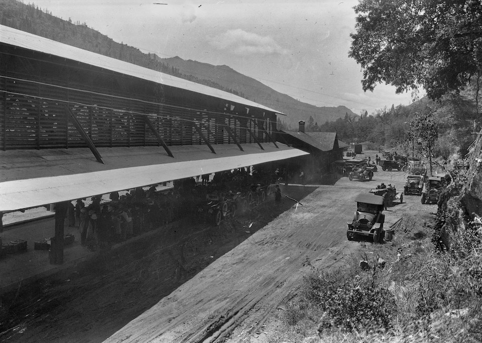 A long building with cars adjacent to it.