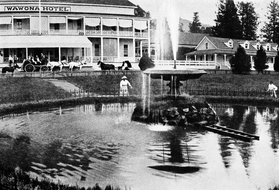 Fountain with stagecoach and building in background