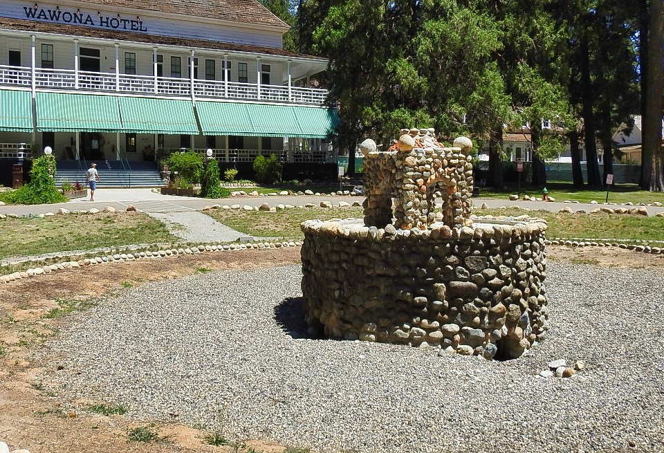 Fountain with stagecoach and building in background