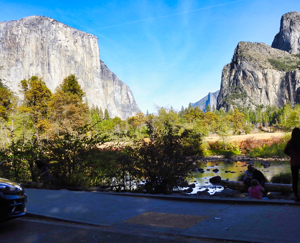 Painting of a river with cliffs, trees, and clouds in background.