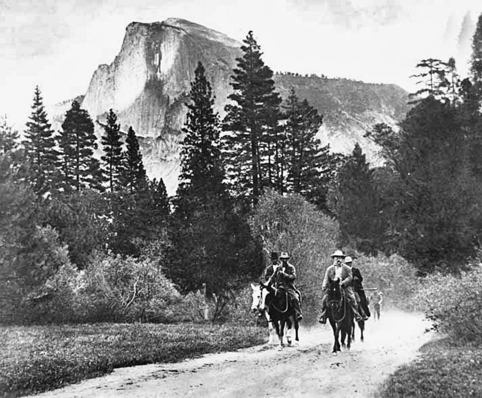 Roosevelt and Muir on horseback with a mountain in the background.