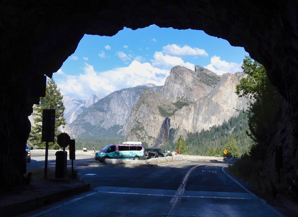 Photo from inside a tunnel with icicles, snow, and mountains visible.