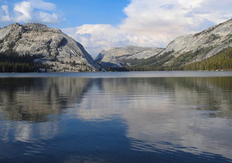 A man skiing on a lake in winter with mountains in background.