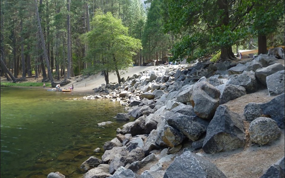 Housekeeping Camp riverbank with large riprap (rocks) in foreground.