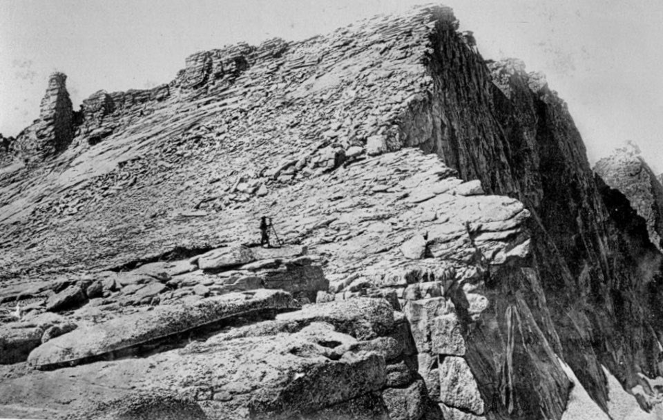 Man standing near top of mountain peak